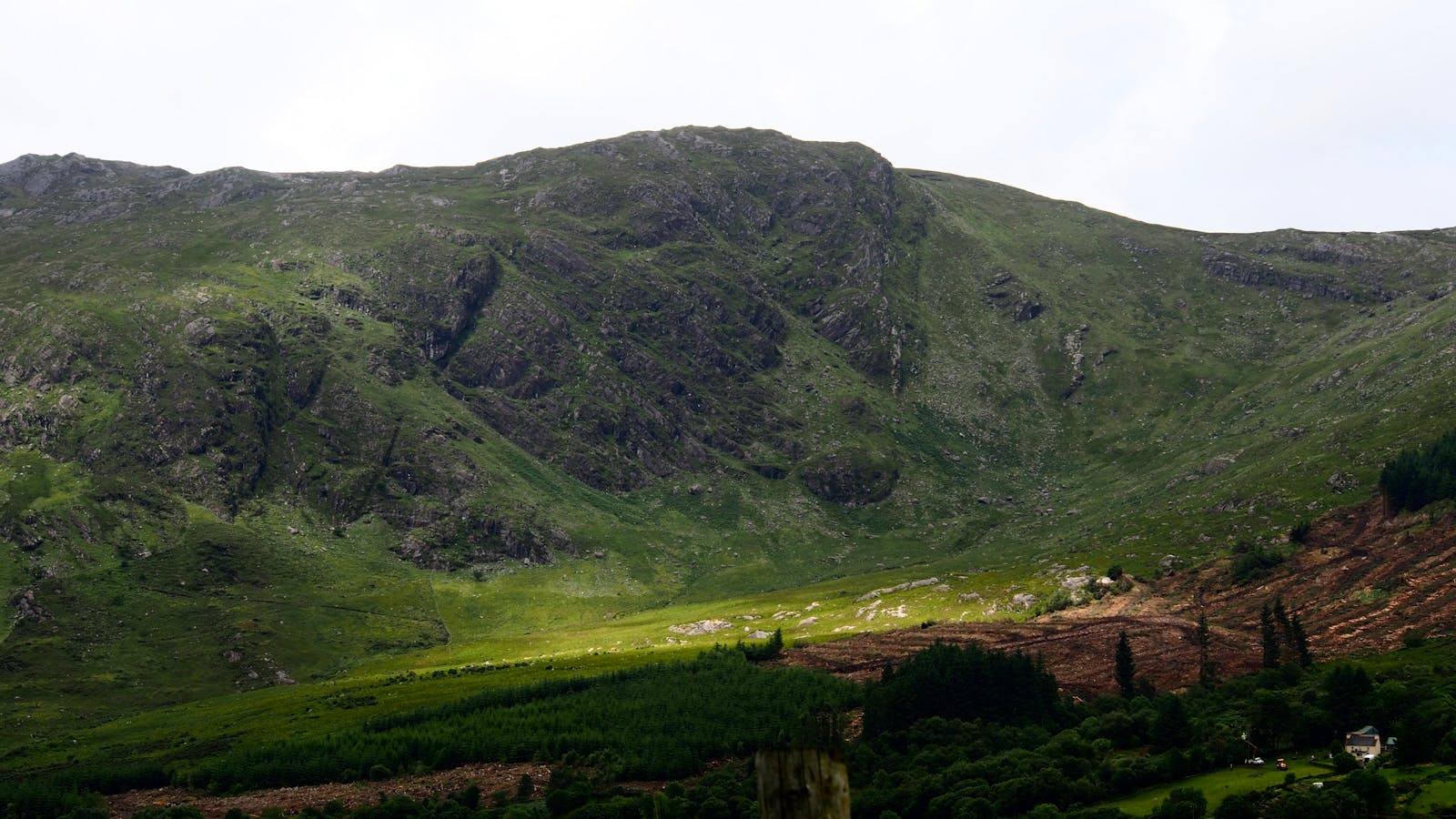 A captivating view of lush green mountains in County Galway, Ireland under a cloudy sky.